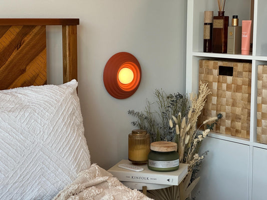Circa scone wall lamp in a cozy bedside setting.