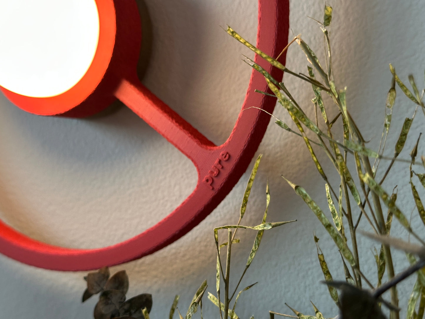 Close-up shot of the Red wireless ORA sconce. 