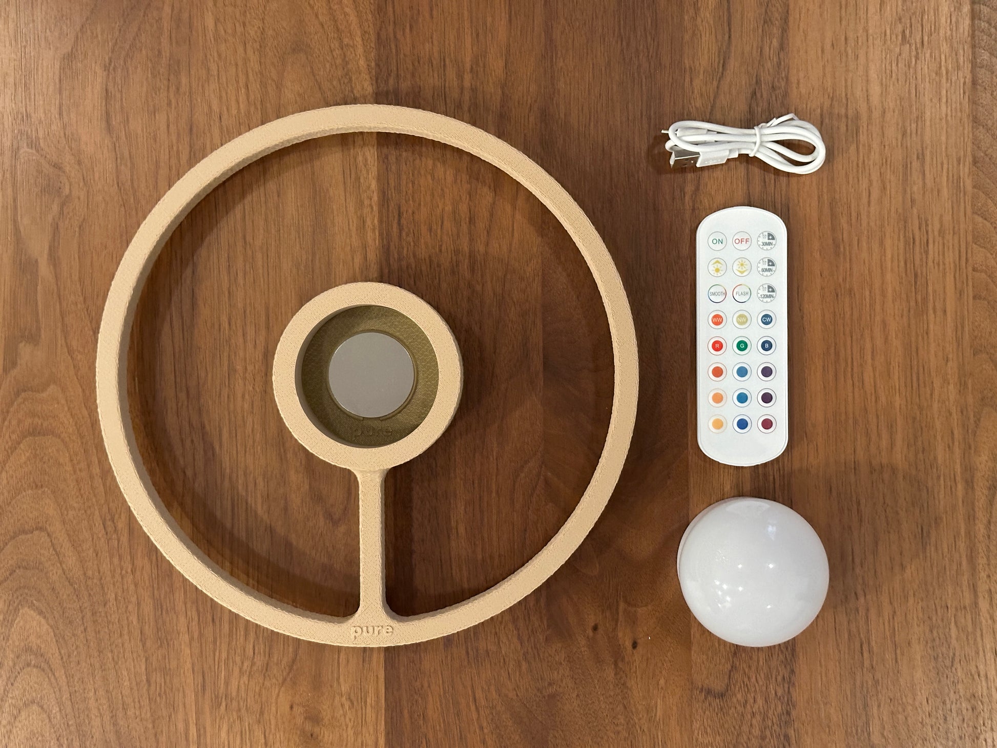 Pure MDRN ORA sconce in Sand color with all the accessories laid out .