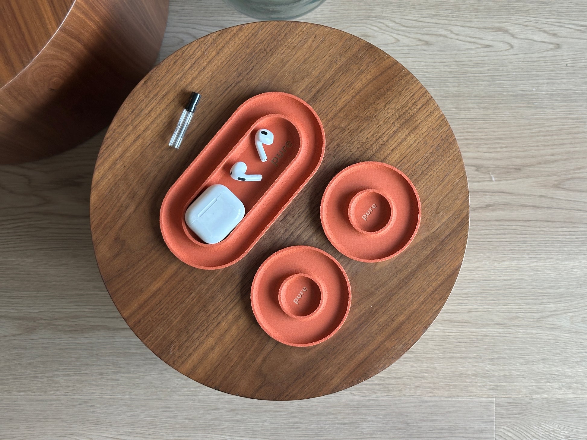 Terracotta catchall tray set holding small accessories, showing the long tray and two round dishes.
