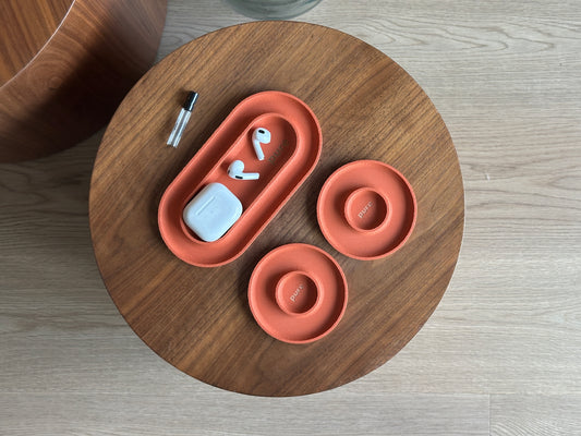 Terracotta catchall tray set holding small accessories, showing the long tray and two round dishes.