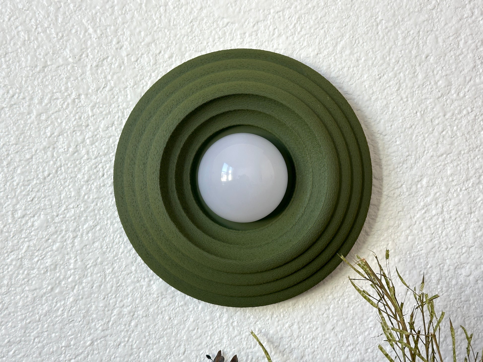 Circa Wireless Wall Sconce in the Moss Green color-way, turned off. 