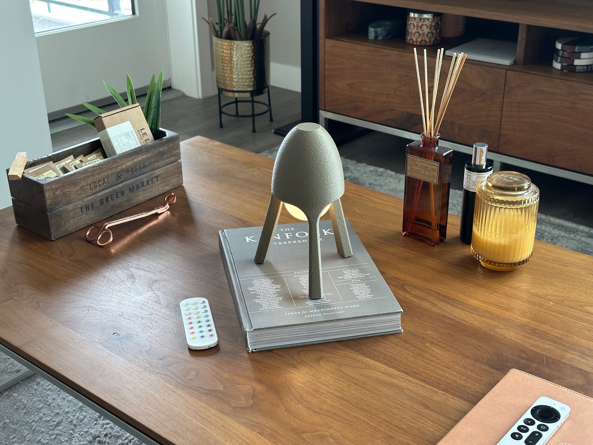 Soma wireless lamp angled on walnut coffee table with soft candle, modern minimalist ambient lighting