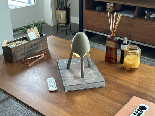 Soma wireless lamp angled on walnut coffee table with soft candle, modern minimalist ambient lighting
